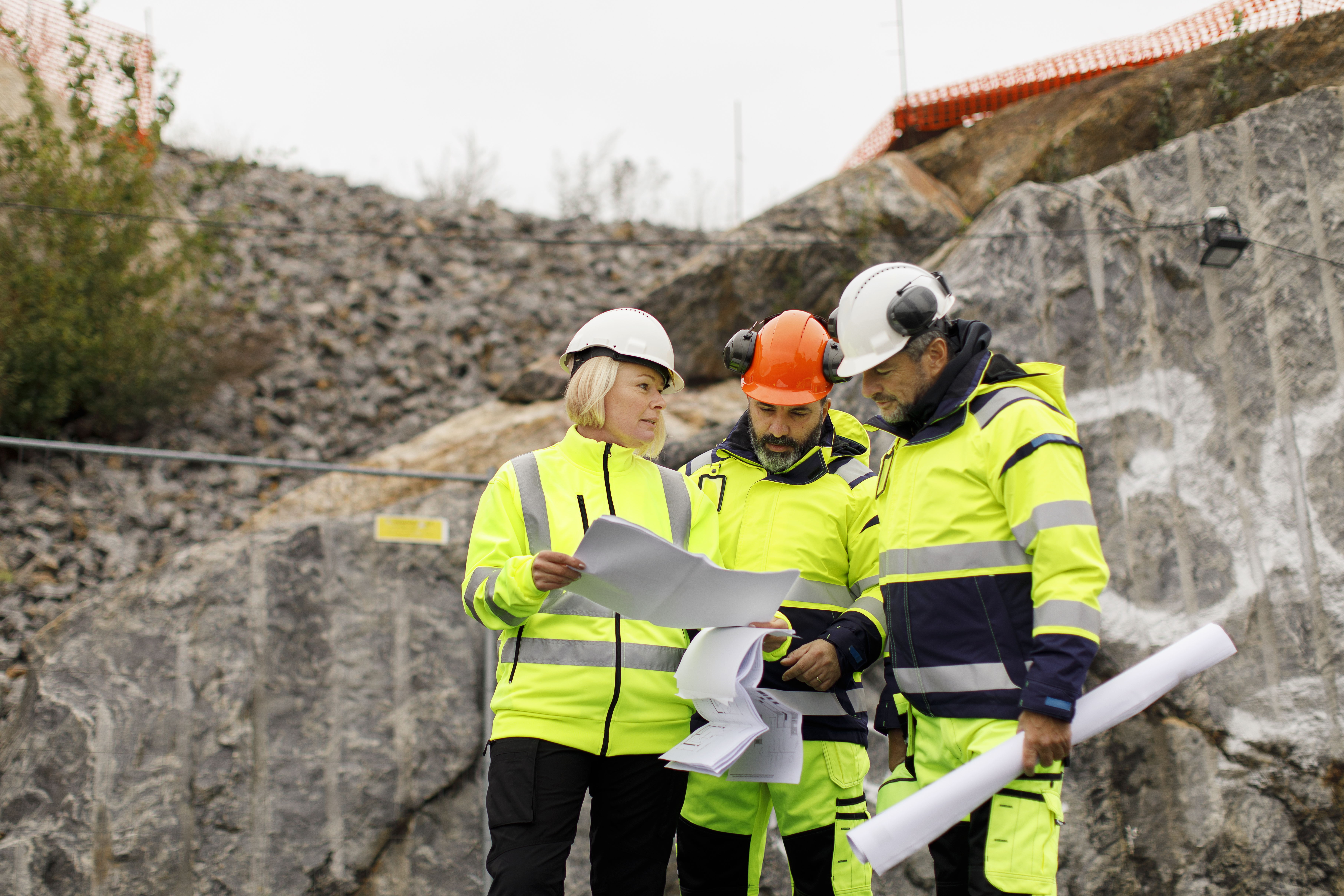 En grupp byggarbetare har ett planeringsmöte utomhus